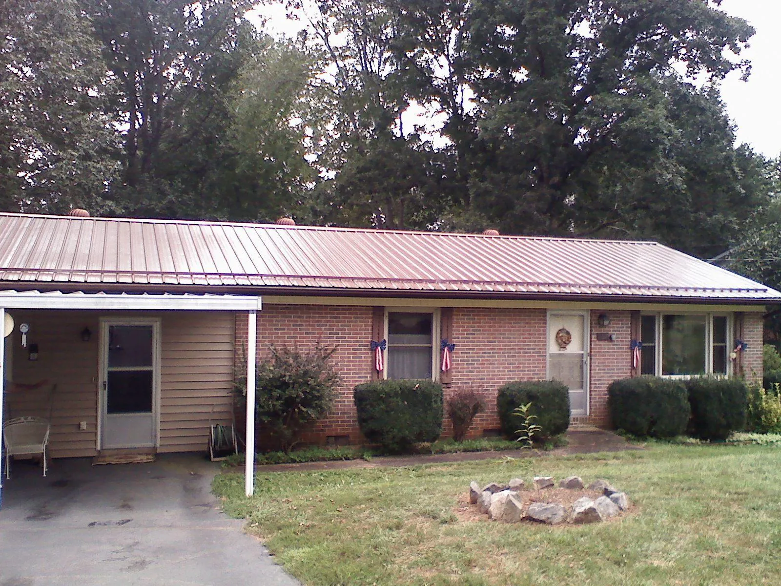 Bronze metal roof and carport on a brick ranch home — Roof Repair work by our crew in Hickman
